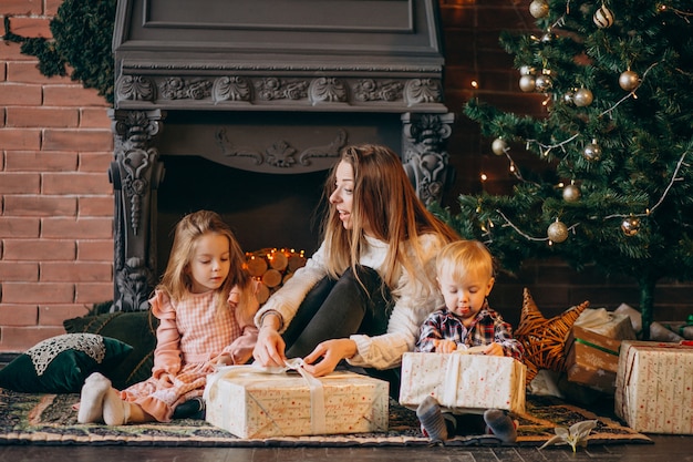 Mère avec enfants par sapin de Noël