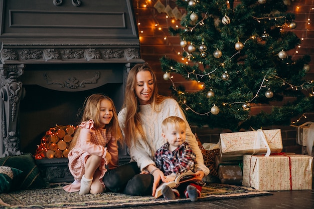 Mère avec enfants par sapin de Noël