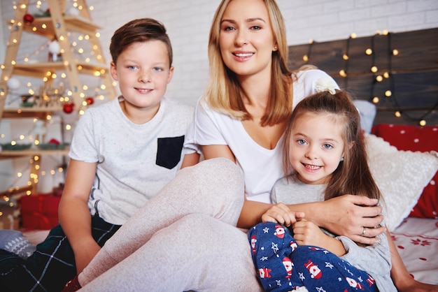 Mère et enfants passer le matin de Noël au lit