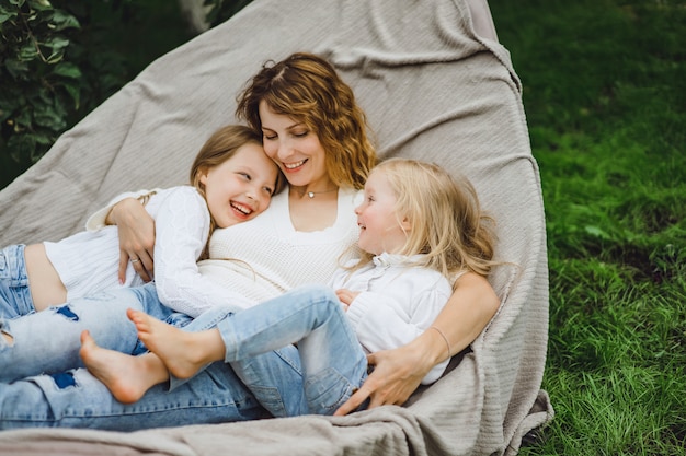 mère avec enfants s&#39;amusant dans un hamac. Maman et enfants dans un hamac.