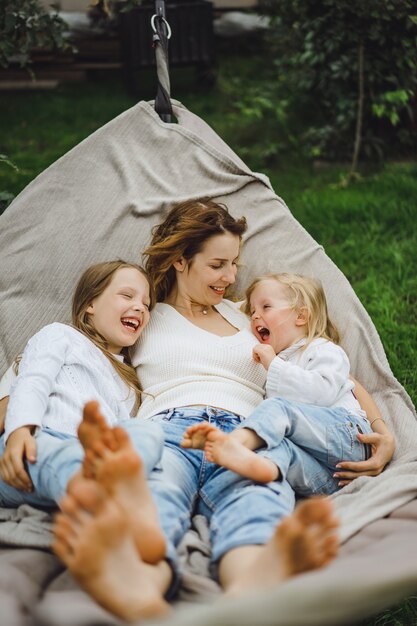 mère avec enfants s&#39;amusant dans un hamac. Maman et enfants dans un hamac.