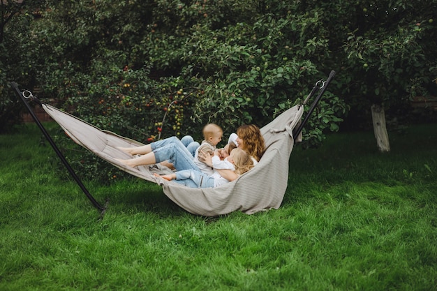 mère avec enfants s&#39;amusant dans un hamac. Maman et enfants dans un hamac.