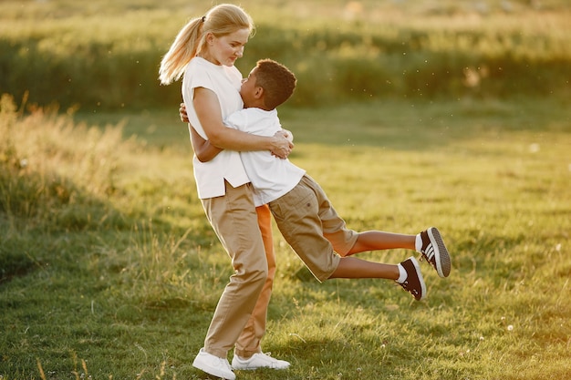 Mère européenne et fils africain. Famille dans un parc d'été.