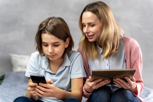 Photo gratuite mère et fille avec des appareils