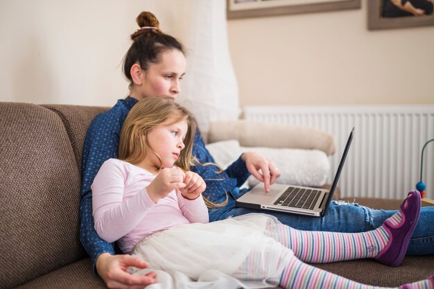 Mère et fille assis ensemble à l&#39;aide d&#39;un ordinateur portable