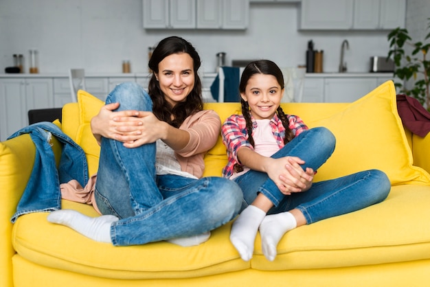 Mère et fille assise sur le canapé