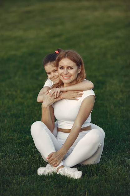 Mère avec fille assise sur une herbe