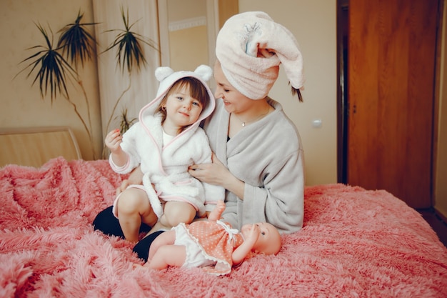 Mère avec fille assise sur un lit