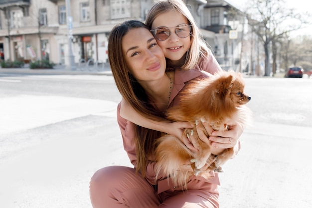 mère et fille avec chien dans la rue