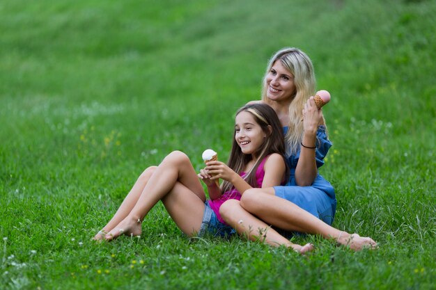 Mère et fille couchée dans l'herbe avec de la glace