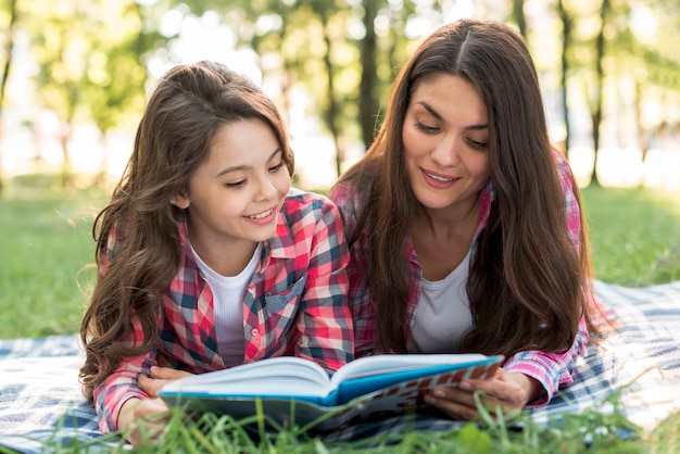 Mère, fille, coucher couverture, livre lecture, ensemble