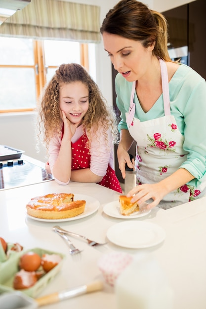 Mère et fille de coupe crêpes dans la cuisine