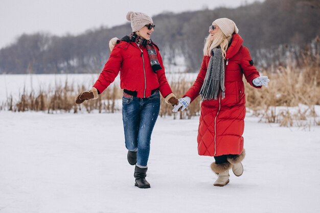 Mère et fille courir sur le lac en hiver