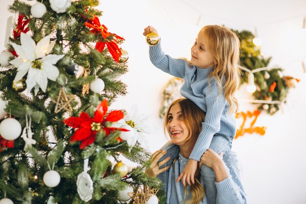 Mère avec fille décorer un arbre de Noël
