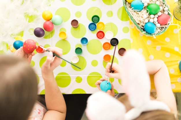 Mère et fille décorer des oeufs de Pâques