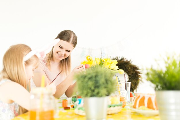 Mère et fille décorer des oeufs de Pâques