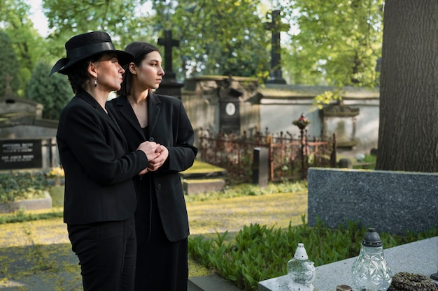 Mère et fille en deuil sur une tombe du cimetière