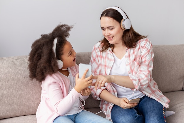 Photo gratuite mère fille, écouter musique, chez soi