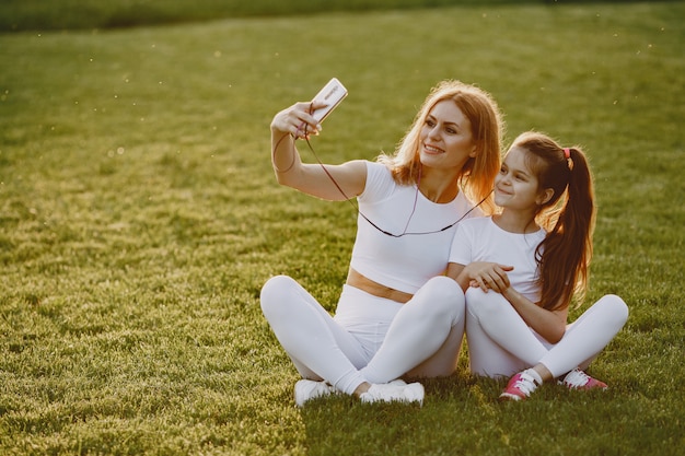 Mère avec fille écouter de la musique dans un parc