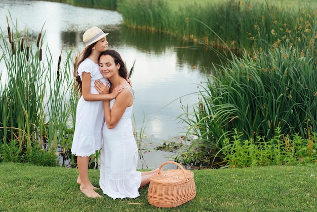 Photo gratuite mère et fille embrassant au bord du lac