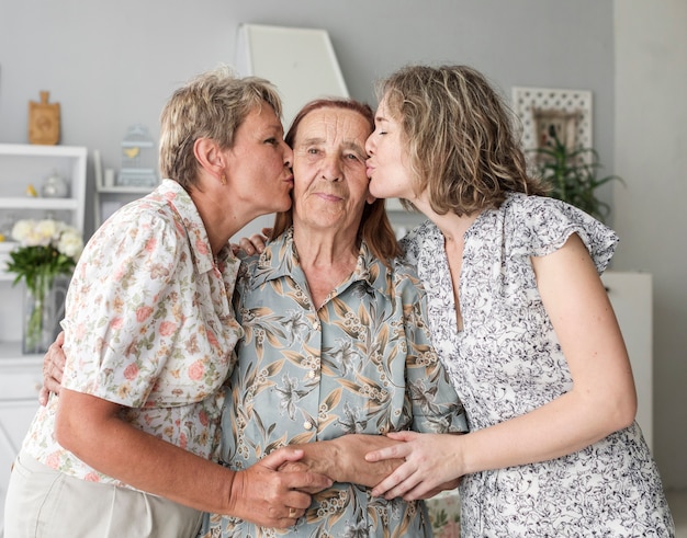 Mère et fille embrassant leur grand-mère à la maison