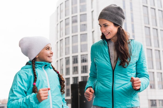 Photo gratuite mère et fille de faible angle en cours d'exécution