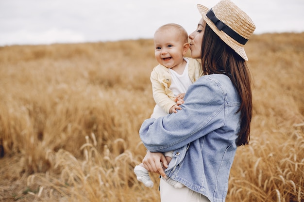 Mère avec fille jouant dans un champ d'automne