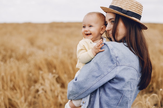 Mère avec fille jouant dans un champ d'automne