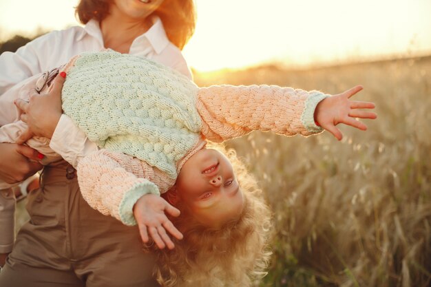 Mère avec fille jouant dans un champ d'été