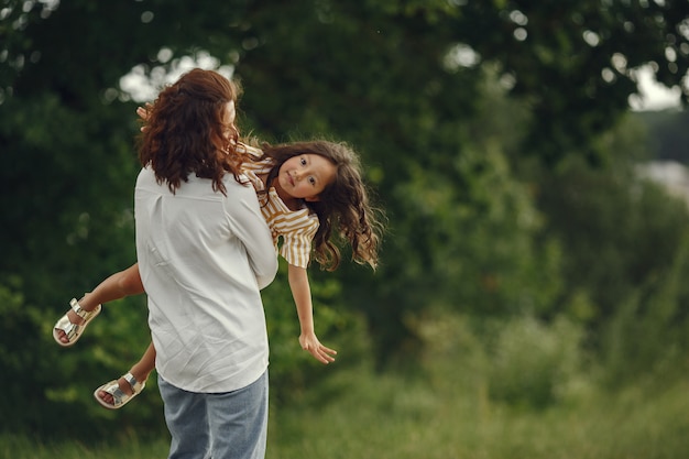 Mère avec fille jouant dans un champ d'été