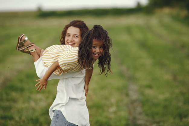 Mère avec fille jouant dans un champ d'été