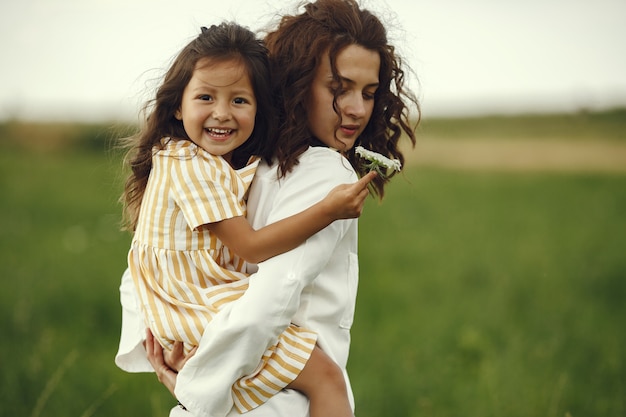 Mère avec fille jouant dans un champ d'été