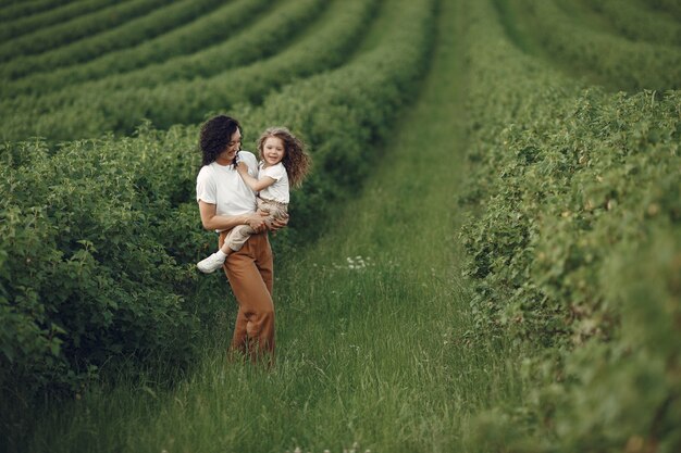 Mère avec fille jouant dans un champ d'été