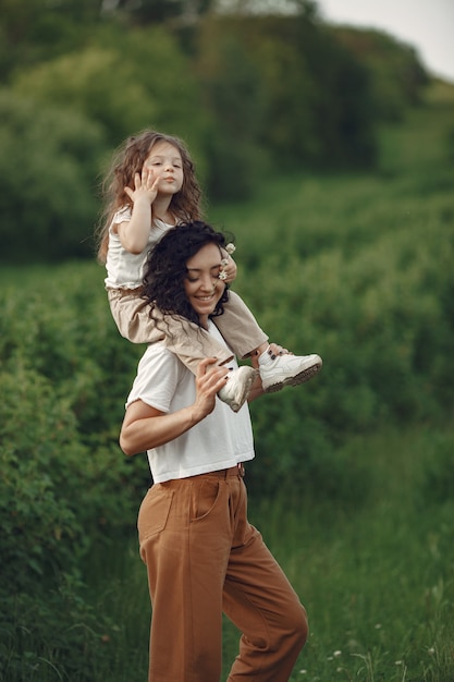 Mère avec fille jouant dans un champ d'été