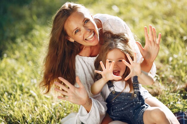 Mère avec fille jouant dans un parc d'été