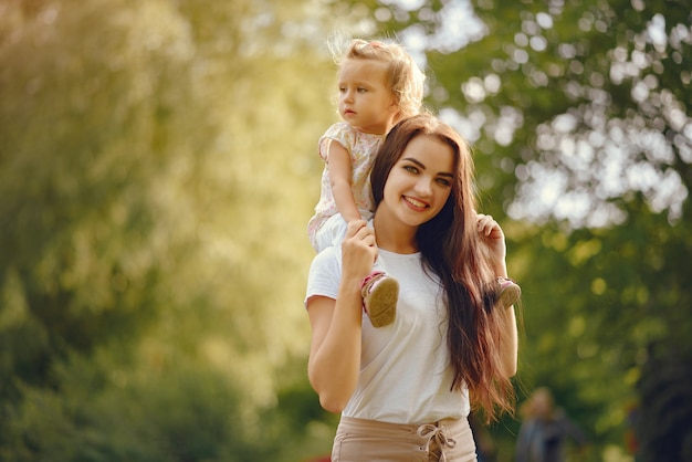 Mère avec fille jouant dans un parc d'été