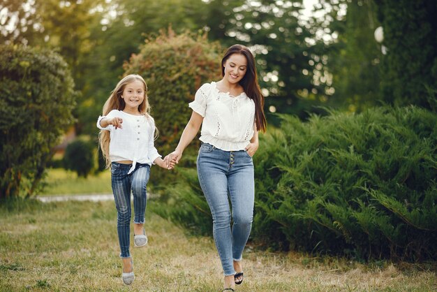 Mère avec fille jouant dans un parc d'été