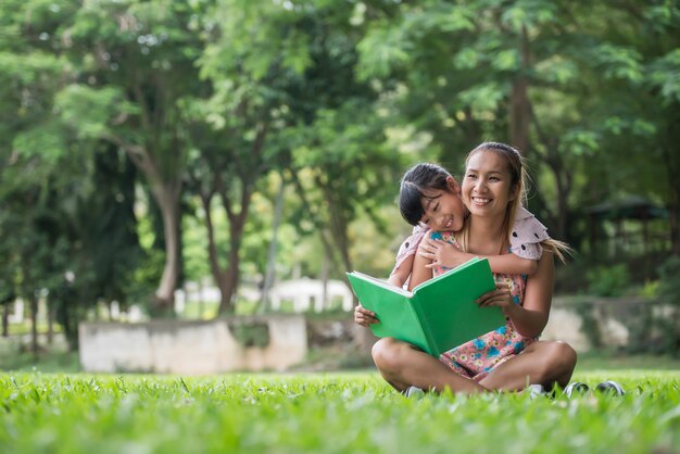 Mère et fille lisant un conte de fées à sa fille dans le parc