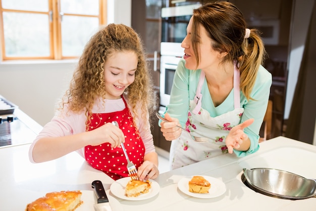 Mère et fille de manger crêpes dans la cuisine