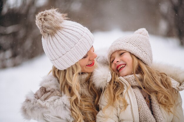 Mère avec fille marchant ensemble dans un parc d&#39;hiver