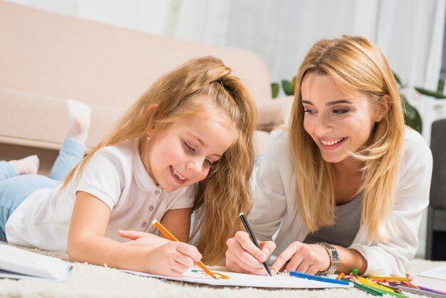 Mère et fille peignant sur le sol