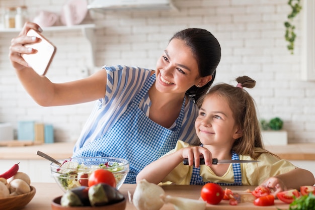 Mère et fille prenant selfie dans la cuisine