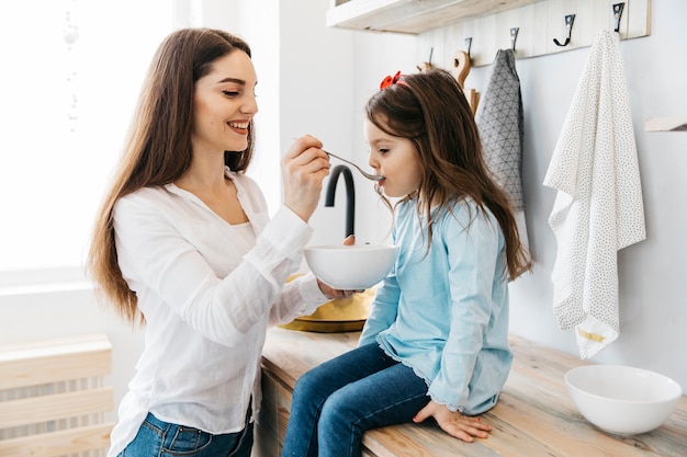 Photo gratuite mère et fille prenant son petit déjeuner