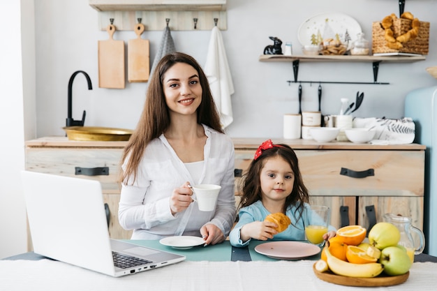 Photo gratuite mère et fille prenant son petit déjeuner