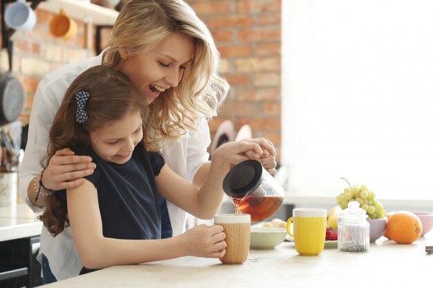 Mère fille, préparer thé, tasse