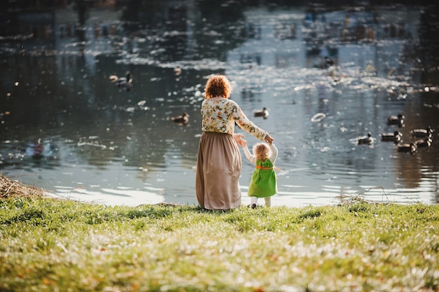 La mère avec une fille regardant le lac