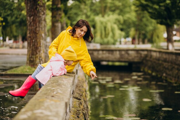 Mère et fille s'amusant dans le parc par temps de pluie