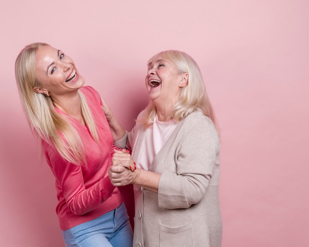 Photo gratuite mère et fille se tenant la main et couchait