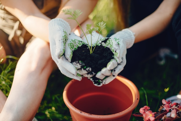 Mère avec une fille travaille dans un jardin près de la maison