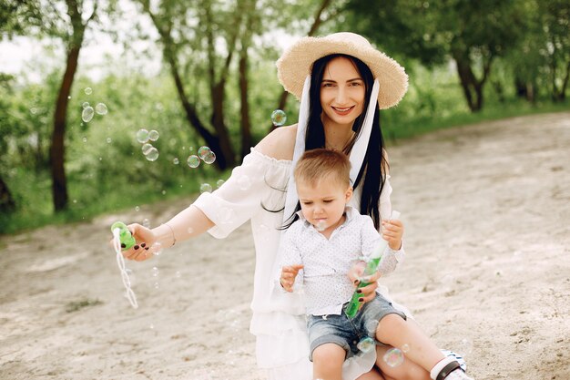 Mère avec fils jouant dans un parc d'été